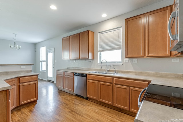 kitchen with stainless steel appliances, sink, a wealth of natural light, and decorative light fixtures