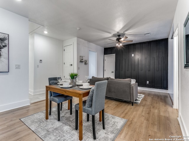 dining space featuring ceiling fan, a textured ceiling, and light hardwood / wood-style flooring