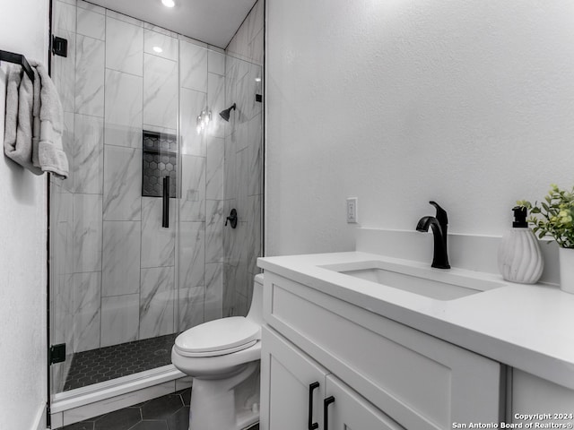 bathroom with vanity, toilet, tile patterned floors, and a shower with shower door