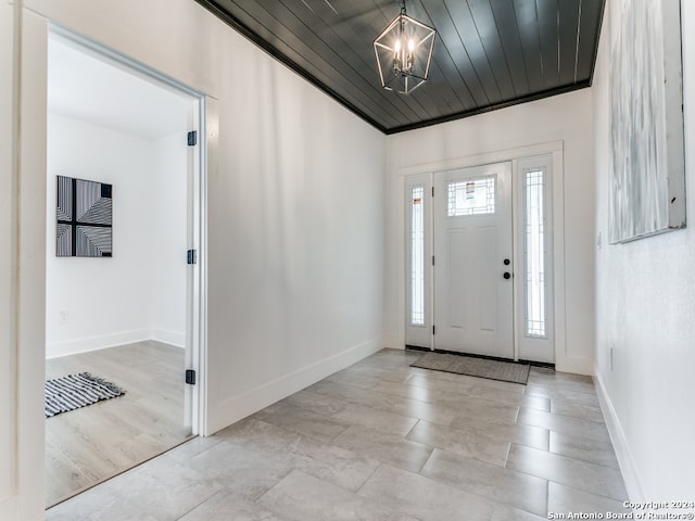 foyer entrance with an inviting chandelier and wooden ceiling