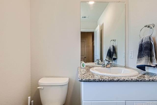 bathroom with visible vents, toilet, and vanity