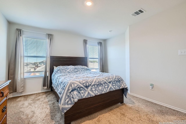 carpeted bedroom with visible vents and baseboards