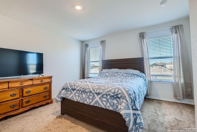 bedroom featuring light colored carpet and baseboards