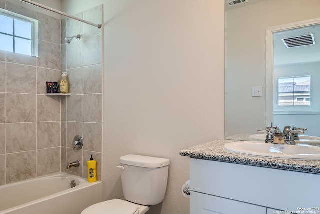 full bathroom featuring vanity, toilet, a healthy amount of sunlight, and tiled shower / bath