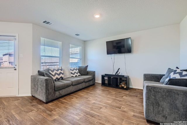living room with visible vents, baseboards, and light wood-type flooring