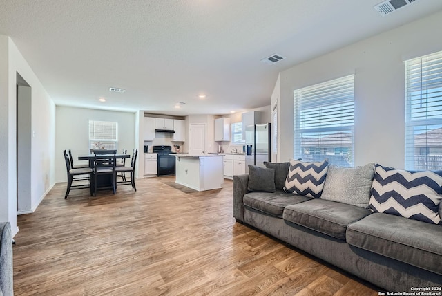 living room with visible vents, light wood-style floors, and recessed lighting
