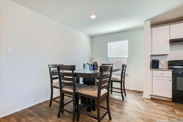 dining space featuring baseboards and light wood-type flooring