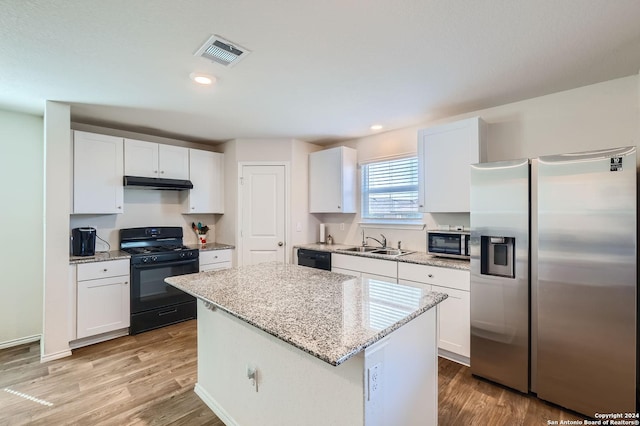 kitchen featuring white cabinets, a sink, visible vents, under cabinet range hood, and black appliances