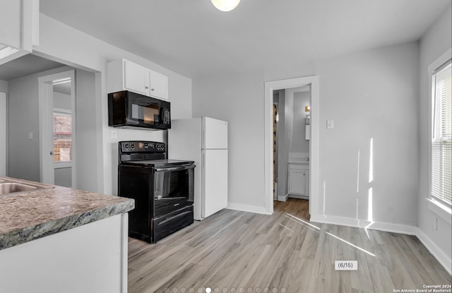 kitchen with black appliances, white cabinetry, light wood-type flooring, and plenty of natural light