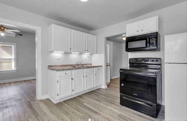 1627 Montezuma St, San Antonio, TX 78207 - kitchen with black appliances, white cabinetry, a sink, and light wood-style flooring