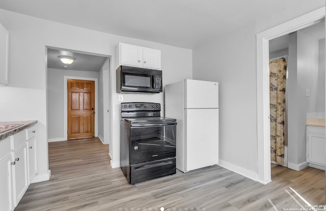 kitchen with light hardwood / wood-style flooring, white cabinets, and black appliances