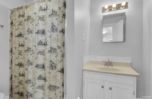 bathroom featuring vanity, toilet, and walk in shower