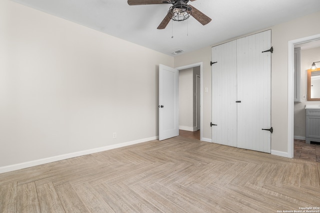 unfurnished bedroom featuring connected bathroom, ceiling fan, and light parquet flooring