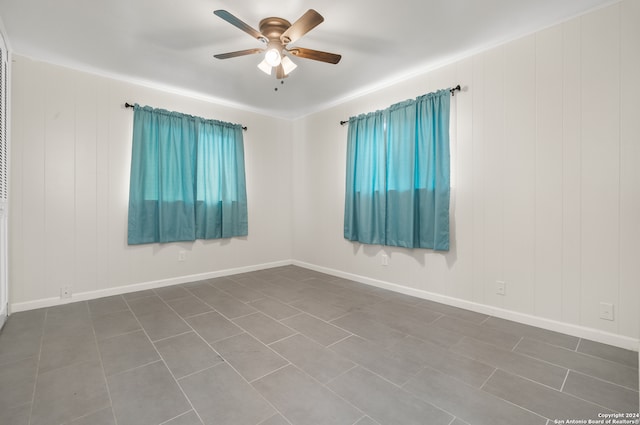 tiled spare room with ceiling fan