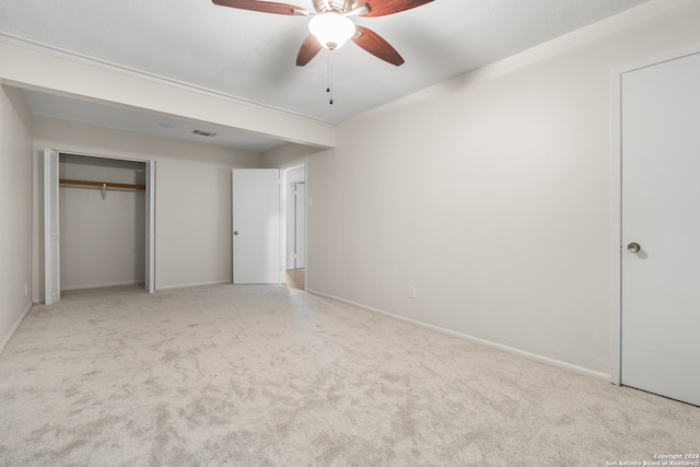 unfurnished bedroom with a closet, light colored carpet, and ceiling fan