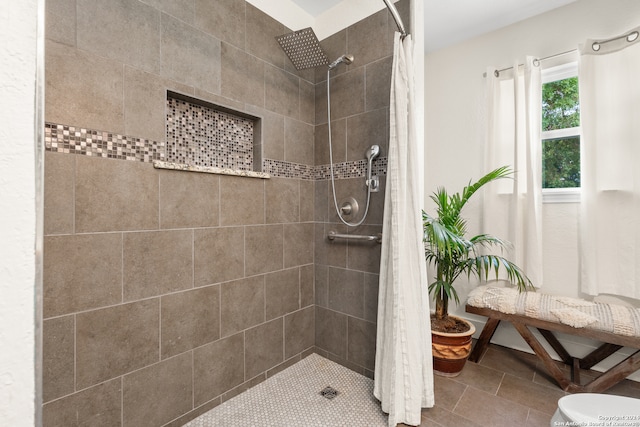 bathroom with toilet, a shower with shower curtain, and tile patterned flooring