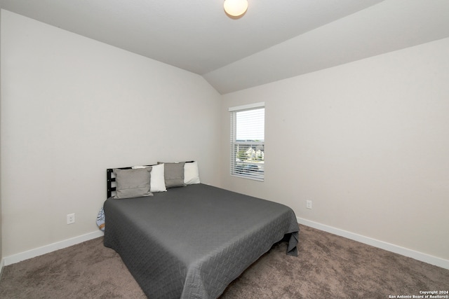 bedroom featuring lofted ceiling and carpet