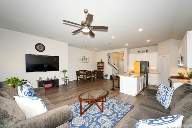 living room with sink, ceiling fan, and dark hardwood / wood-style flooring