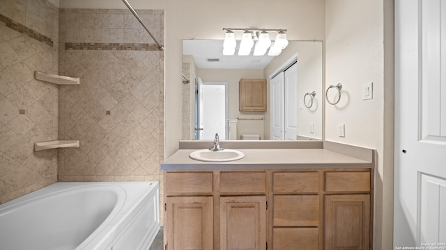 full bathroom featuring toilet, vanity, and tiled shower / bath combo