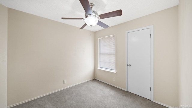 carpeted empty room featuring ceiling fan