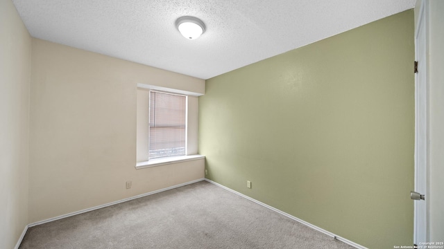 empty room featuring a textured ceiling and carpet flooring