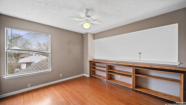 interior space with ceiling fan, a textured ceiling, and hardwood / wood-style flooring