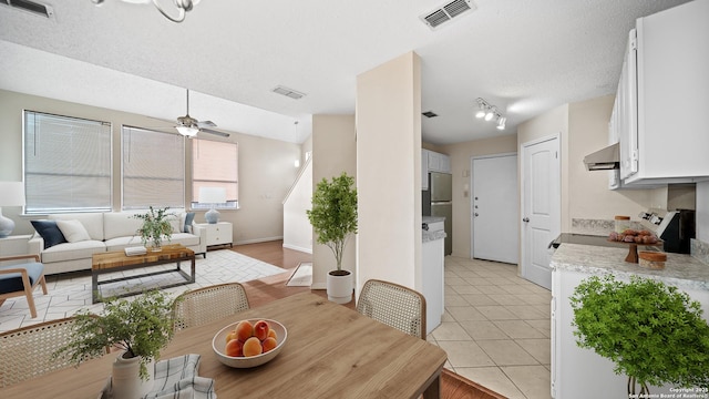 tiled dining room featuring ceiling fan and a textured ceiling