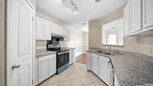 kitchen with light tile patterned floors, white cabinetry, appliances with stainless steel finishes, a textured ceiling, and sink