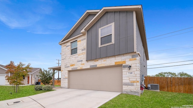 view of front of home with a garage, central air condition unit, and a front yard