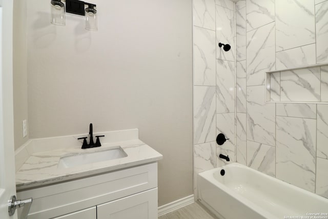 bathroom featuring vanity and tiled shower / bath