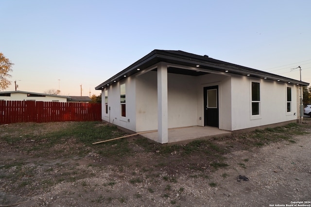 back house at dusk with a patio