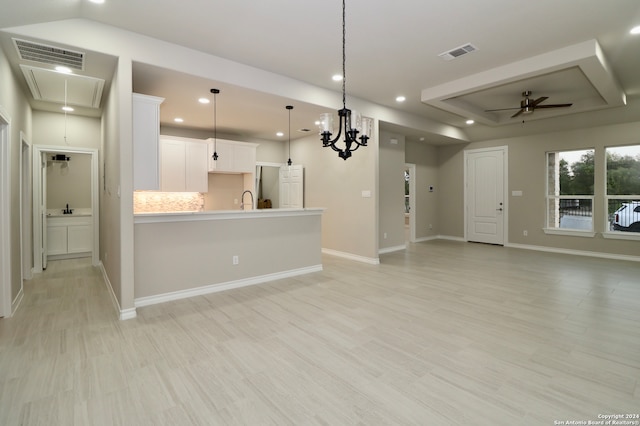 kitchen with decorative backsplash, light hardwood / wood-style flooring, decorative light fixtures, and white cabinets