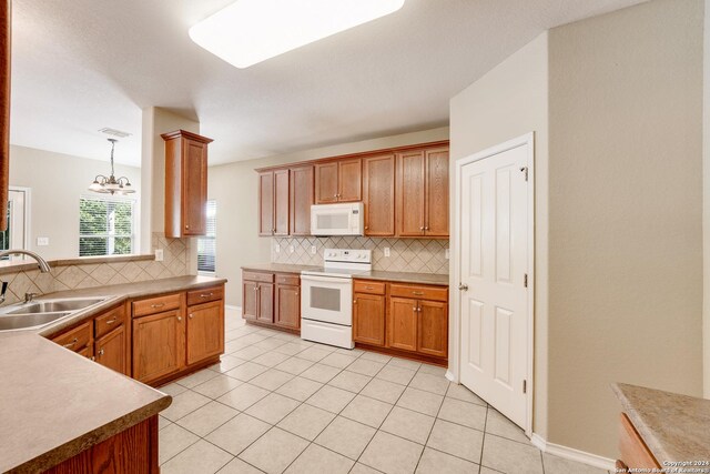 kitchen with light tile patterned flooring, tasteful backsplash, a sink, and white appliances