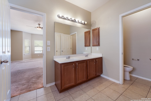 bathroom with toilet, ceiling fan, vanity, and tile patterned flooring