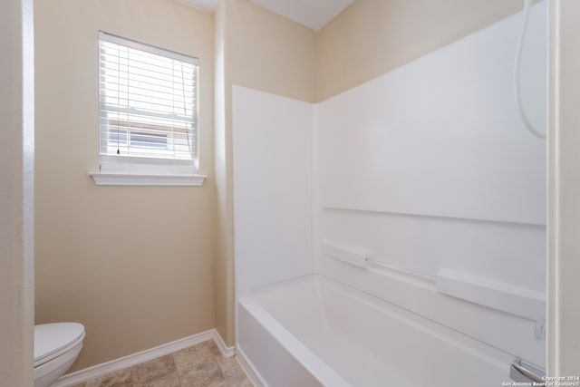 bathroom with toilet and bathing tub / shower combination