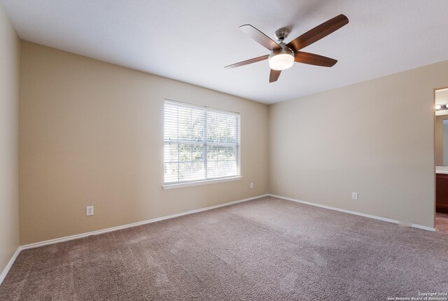 spare room featuring ceiling fan, baseboards, and carpet
