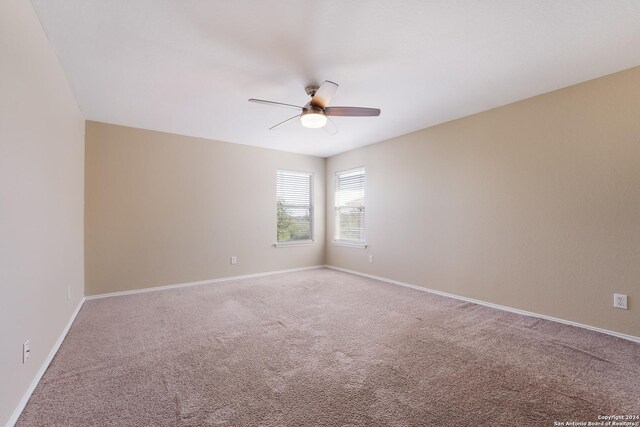 unfurnished room with baseboards, a ceiling fan, and carpet