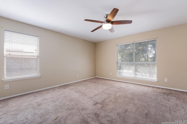 unfurnished room with ceiling fan, baseboards, and carpet