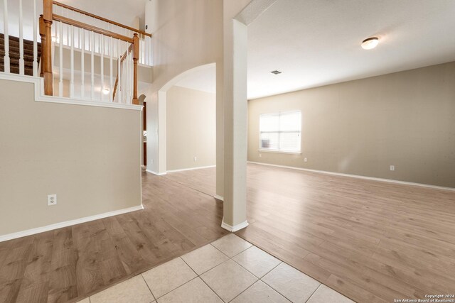 interior space with arched walkways, wood finished floors, and baseboards