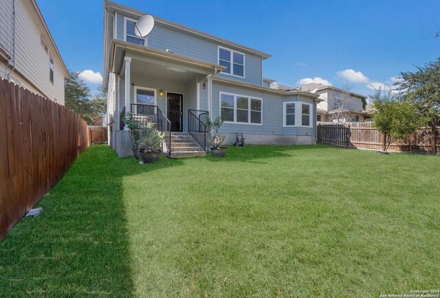 back of house featuring a lawn and a fenced backyard