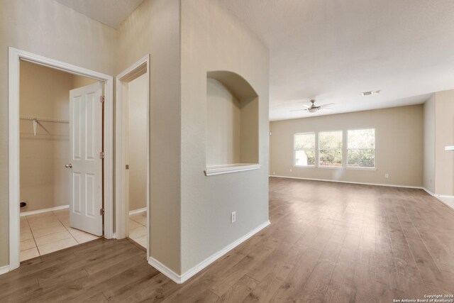 corridor featuring wood finished floors, visible vents, and baseboards