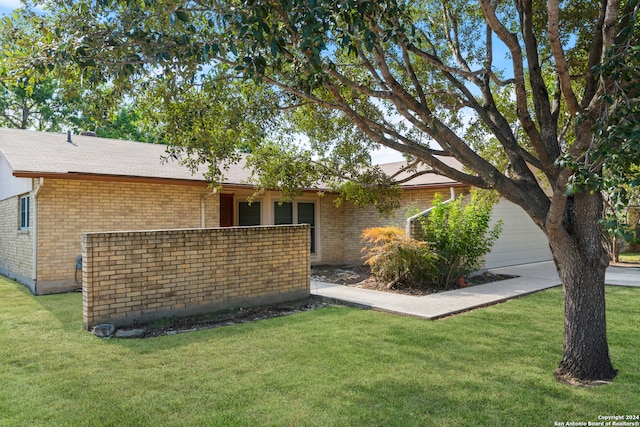 view of front of home with a front yard and a garage