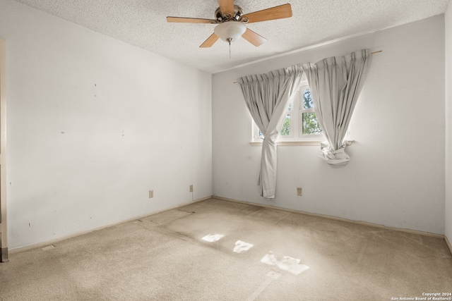 carpeted spare room featuring a textured ceiling and ceiling fan