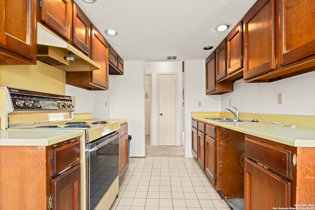 kitchen with a textured ceiling, sink, electric range, and light tile patterned floors