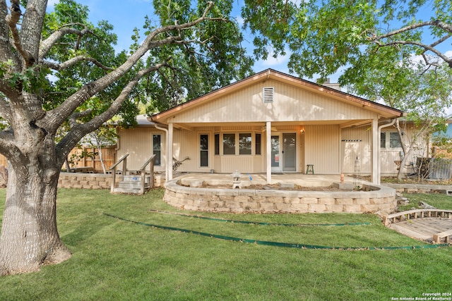 rear view of house featuring a yard and covered porch