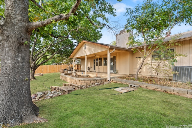 rear view of property featuring a yard, a patio area, and central AC unit