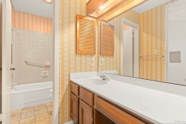 full bathroom featuring vanity, toilet, a textured ceiling, and tiled shower / bath