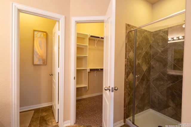 bathroom featuring a shower with door and tile patterned flooring