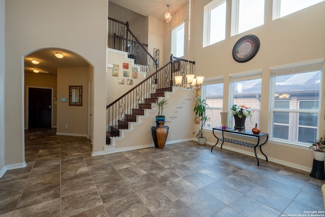 entryway featuring a notable chandelier, a high ceiling, and plenty of natural light