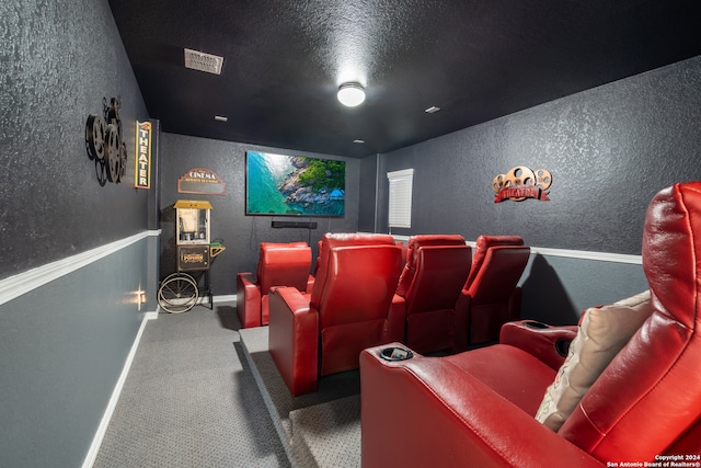 cinema room featuring a textured ceiling and carpet floors